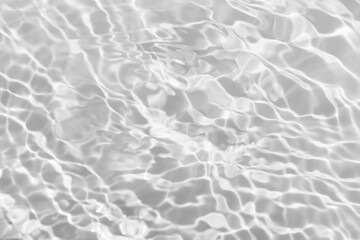 White water with ripples on the surface. Defocus blurred transparent white colored clear calm water surface texture with splashes and bubbles. Water waves with shining pattern texture background.