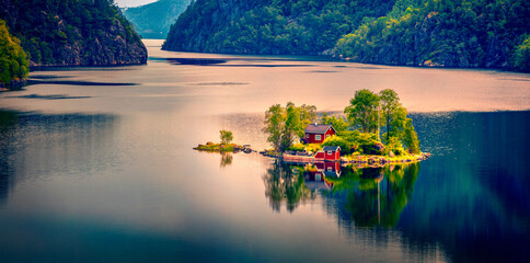 Panoramic summer view with small island with typical Norwegian building with red wall on...