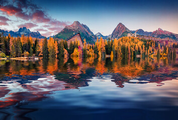 Huge peaks reflected in the calm waters of Strbske pleso lake. Astonishing autumn scene of High...