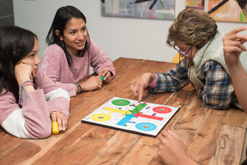 Multi-generational family playing board games at home