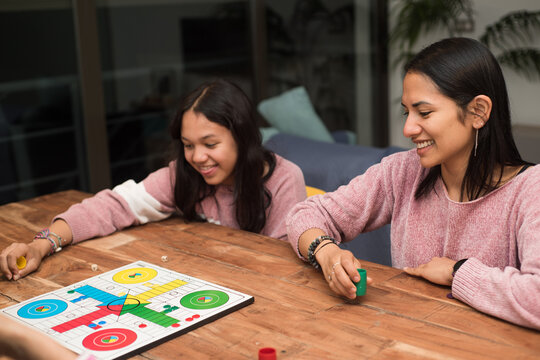 Family playing ludo board game on the living room at home