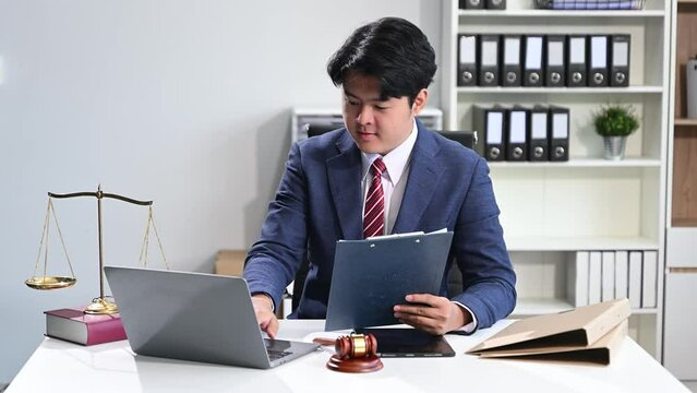 Asian man lawyer working and gavel, tablet, laptop. justice and law concept.