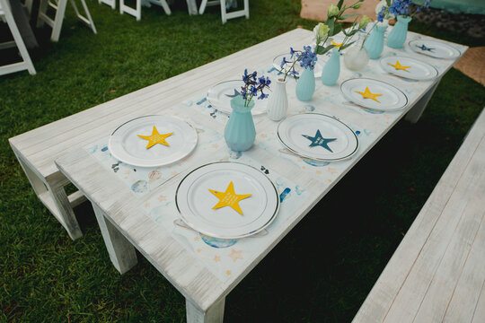 Mesa con floreros y platos para cumplea&ntilde;os