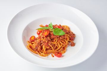 Spaghetti Tomato Sauce with Minced Pork (Bolognese) top with basil leaves served on white plate isolated on white background.