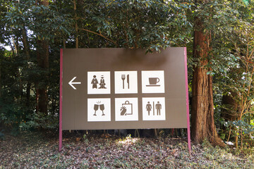 Brown sign or symbol give large directions canteen, restaurant, cafeteria. Located under large tree...