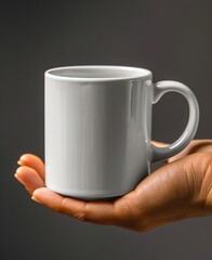 Hand holds white coffee cup.