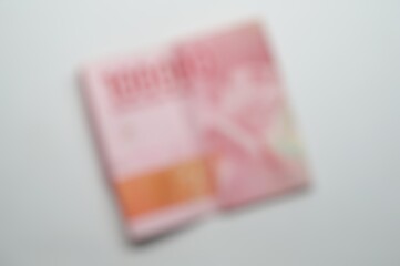 defocused abstract background of a folded 100,000 Rupiah note with a background