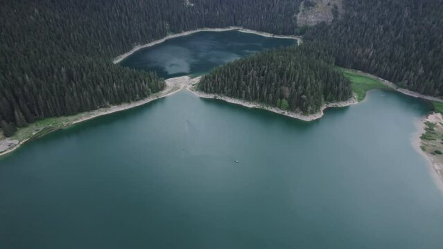 Aerial video, Crno Jezero or Black Lake, pine forest and cliffs in Dormitor National Park, Zabljak