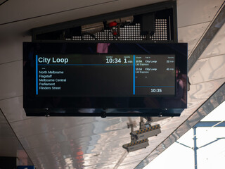 A digital screen displays real-time information at the railway station, showing that the city loop...