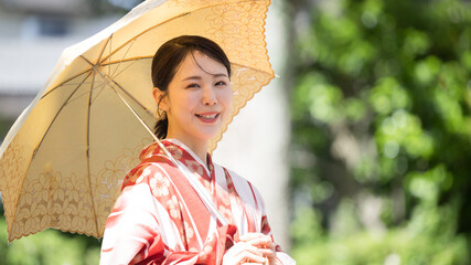 Japanese woman in yukata with parasol looking at camera