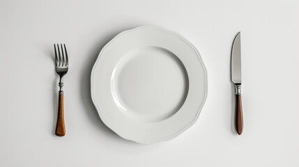 Top-down view of a white plate on a table, with a fork and knife positioned symmetrically, creating a serene scene on a clean white background