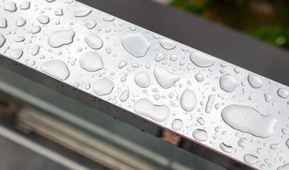 Drops of water from rain on a metal railing