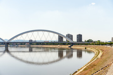 Modern bridge above Danube in front of city. Žeželj Bridge. Landscape of Novi Sad city in Serbia.