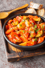 Vegetable stew of zucchini, peppers, onions, tomatoes and eggplant close-up in a bowl on the table. Vertical