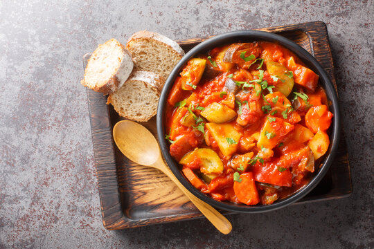 Summer Vegetable spicy stew of zucchini, potatoes, peppers, onions, tomatoes and eggplant close-up in a bowl on the table. Horizontal top view from above
