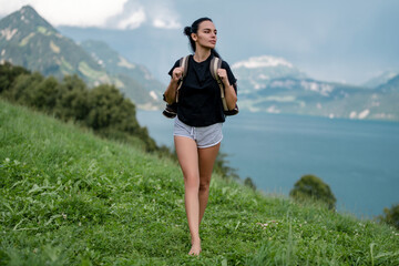 Girl in mountains. Woman hikers trekking in mountains. Young woman walking with backpacks in Alps lake. Woman with big backpack at mountains and blue lake. Travel and tourism. The Hiking.