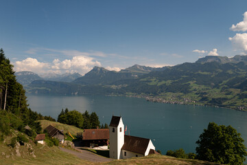 Church in alps. Church In Switzerland next to Lake Lucerne. Church in the Alp mountains at Swiss village. Rural church on lake near mountains at Alps countryside. Mountain village.