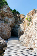 A wooden bridge connects the entrance to the cave
