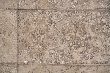 The surface of beige stone tiles with an original natural pattern. Stone texture with space to copy. High quality photo