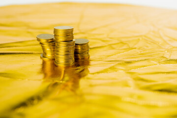 business and finance investment and saving activity with close up gold coin arrange on gold glitter...