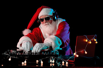 DJ Santa Claus mixing tracks in a nightclub at a Christmas and New Year party or Corporate events....
