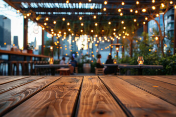 A wooden bar top in the foreground with a blurred background of an urban rooftop bar. The background includes stylish seating, plants, string lights, a panoramic city view.