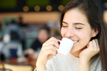 Happy woman drinking in a coffee shop