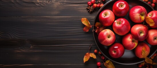 A bowl with red autumn apples on a dark wooden background with knife and autumn leafs Horizontal...