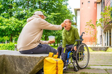 Disabled university student eating with a friend in the campus