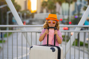 Travelling concept. Child boy and travel suitcase. Kid with travel bad for vacation, child trip. Little tourist with suitcase. Child traveler and baggage. Kid with luggage bags going on holiday trip.