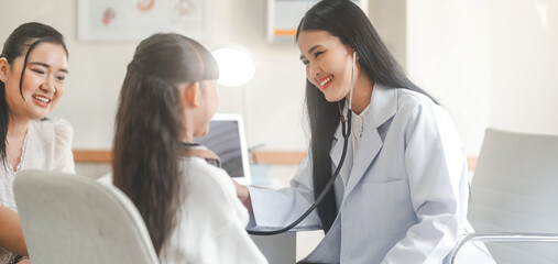 Fototapeta premium Southeast asian Paediatrician doctor woman using stethoscope check little girl health care in kid clinic examining room