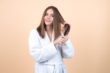 Woman combing her hair. Cares about a healthy and clean hair. Beauty hair salon concept. Girl with...