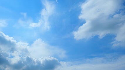 A vibrant blue sky filled with varying types of clouds. Some clouds are thick and puffy, while...
