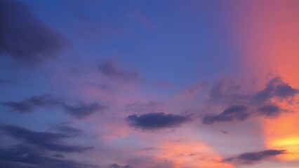 A breathtaking sunset sky with a mix of deep blue, pink, and orange hues. The clouds are darker, creating a dramatic contrast against the vibrant colors, giving a serene and picturesque scene.
