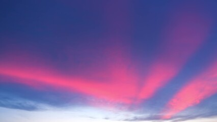 A stunning sunset with vibrant pink and red streaks spreading across the sky. These vivid colors...