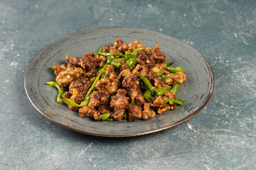 Stir Fried Green Chilli Chicken Dry served in plate isolated on grey background side view of...