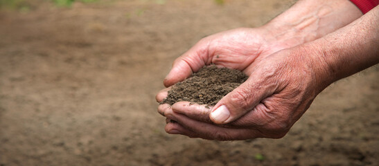 Man's hands holding a handful of earth