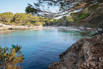 Turqueta cove. Quiet beach in the south of the island of Menorca, in the Balearic Islands, (Spain) seen between rocks and trees showing a lush nature.