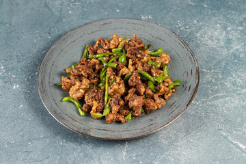 Stir Fried Green Chilli Chicken Dry served in plate isolated on grey background side view of...