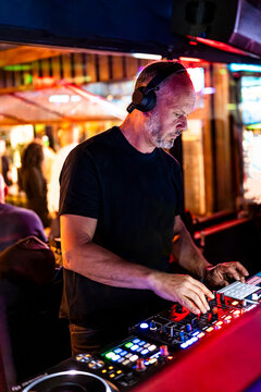 DJ using audio mixer and headphones at nightclub