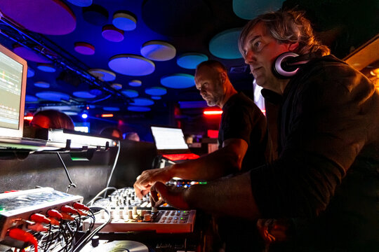 DJs working with sound mixer and performing at night club