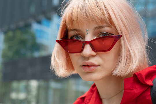 Blond young woman with bindi and red sunglasses