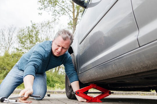 Man installing car jack below car