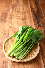 小松菜の笊盛り　木目背景