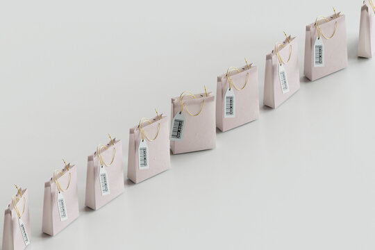 Shopping bags with labels kept in row against gray background