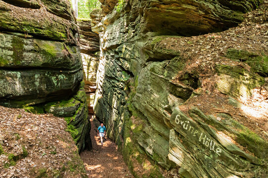 Senior man hiking through sandstone rock formations at Eifel National Park, Bollendorf, The Eifel, Rhineland-Palatinate, Germany