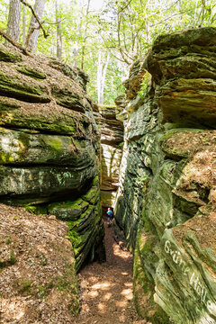 Senior man walking through sandstone rock formations at Eifel National Park, Bollendorf, The Eifel, Rhineland-Palatinate, Germany