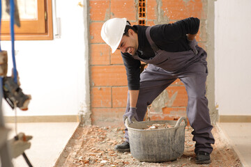 Construction worker suffering back ache lifting work carrycot