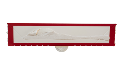 Narrow rectangular white paper with red frame torn from a box packaging