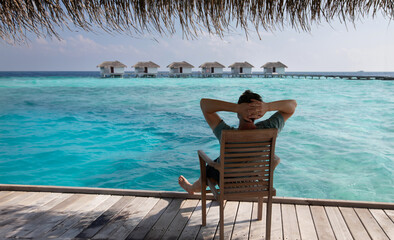 summer holidays, beach vacation in Maldives, man tourist relaxing and enjoying life near turquoise water